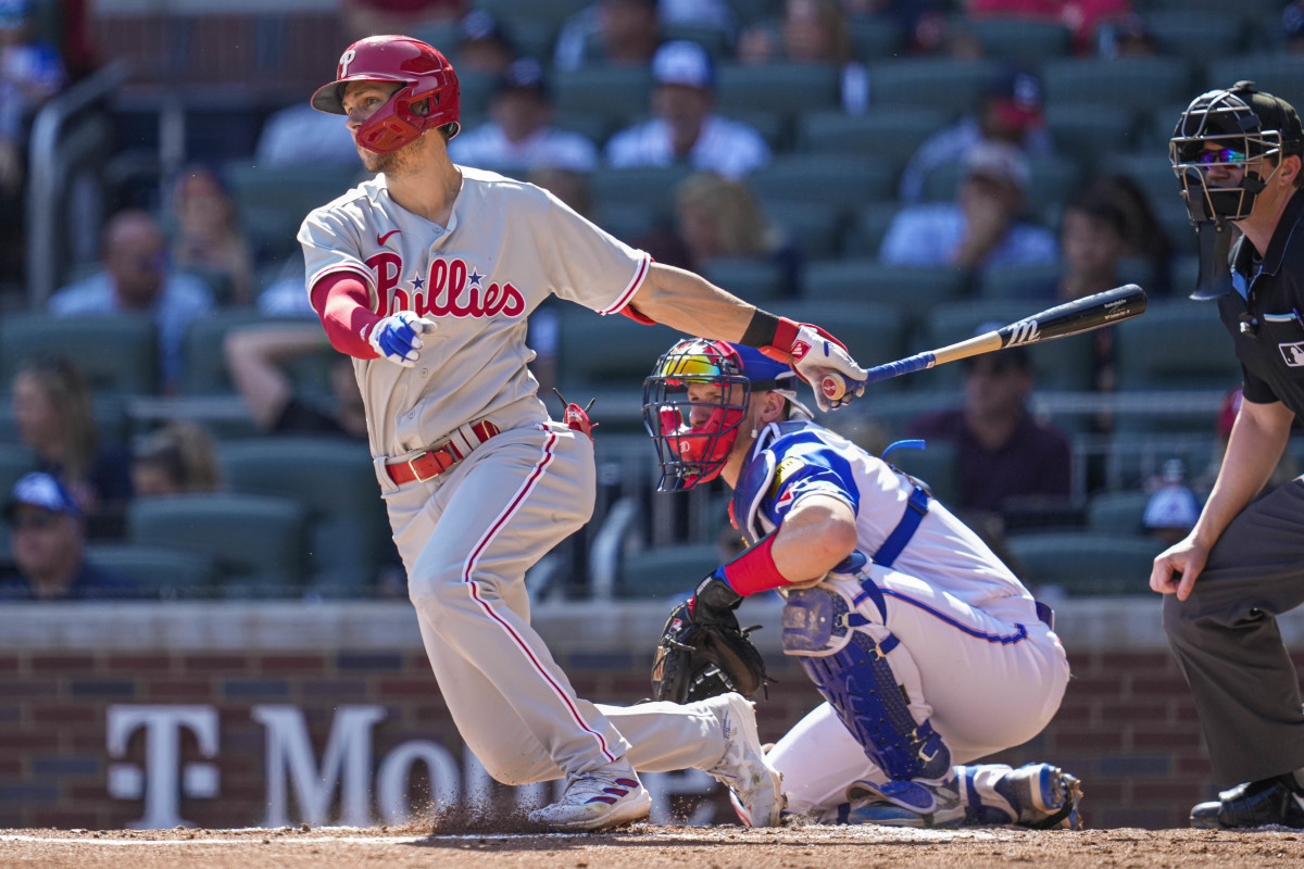 Trea Turner finishes his swing, with his bat behind him and one hand out